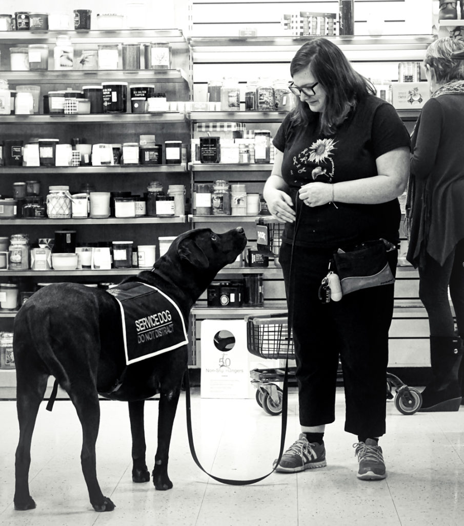 A black and white photo of Kristi and Jax looking into each others' eyes while standing in the store.
