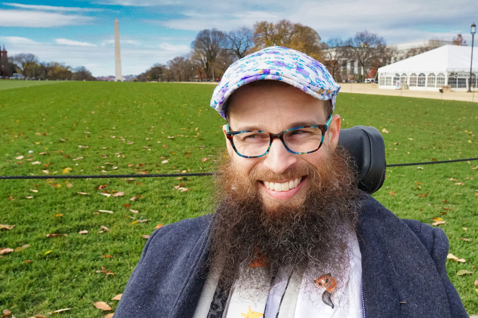 Brad smiles and looks to his right with the Washington Monument in the background.