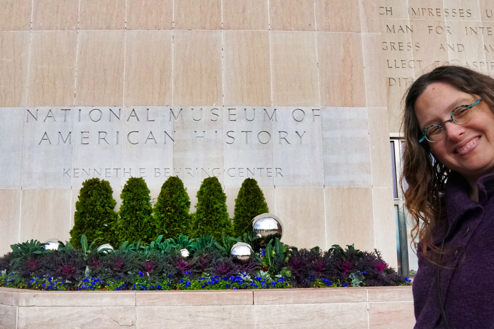A sign for the National Museum of American History with Veronica smiling in the corner of the picture.