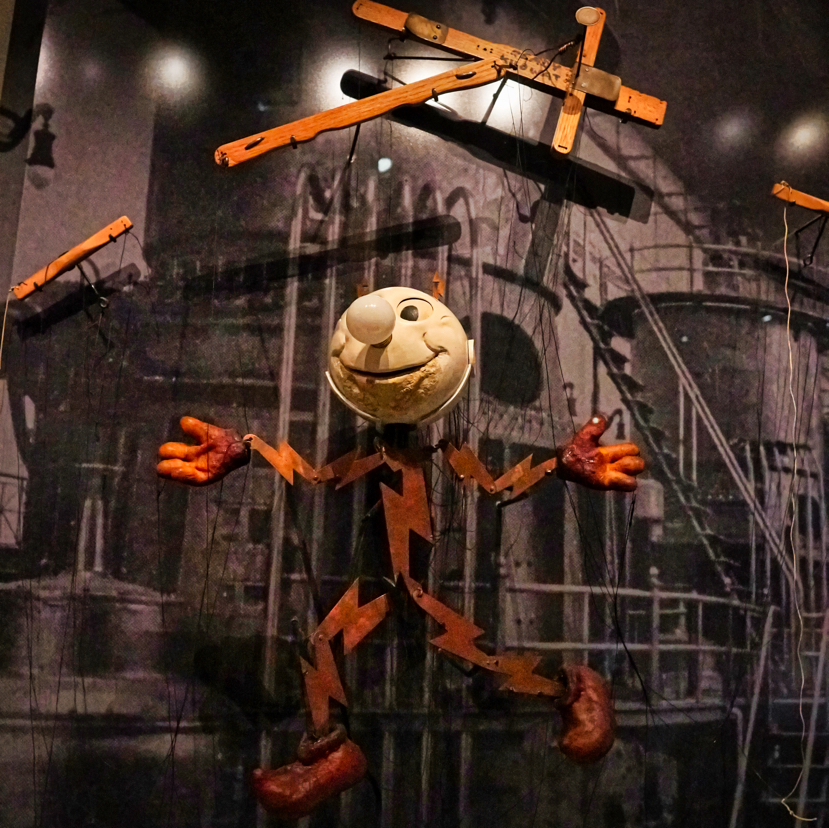 A puppet of a man made out of lighting bolts with a lightbulb for a nose. This puppet was used to introduce people to the idea of electricity.