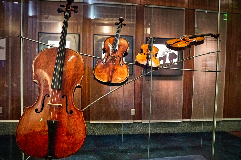 A cello, viola, and two violins are artistically displayed in a curving twist.