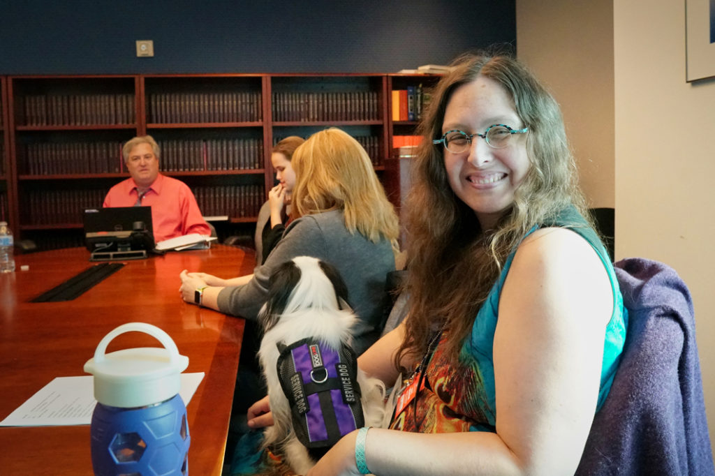Veronica with Hestia on her lap smiles at the camera during our meeting with DOT.