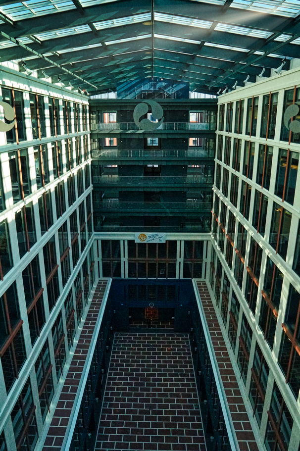 The interior atrium of DOT is a tall space with a brick floor and lots of windows and open light.